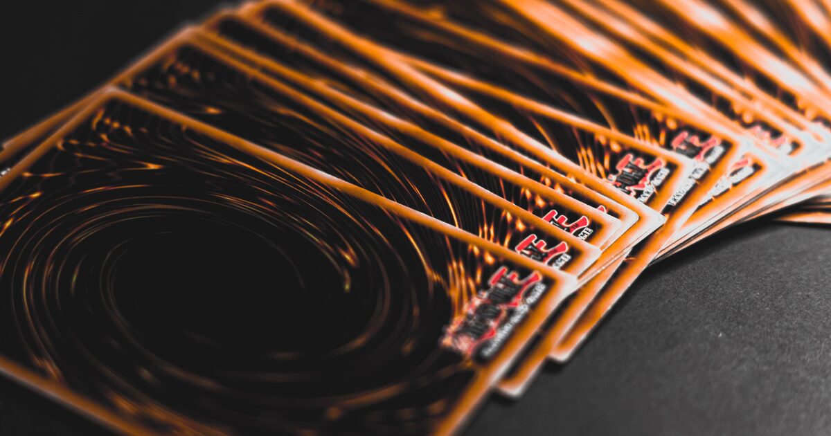 A close-up of collectible trading cards fanned out under warm orange light